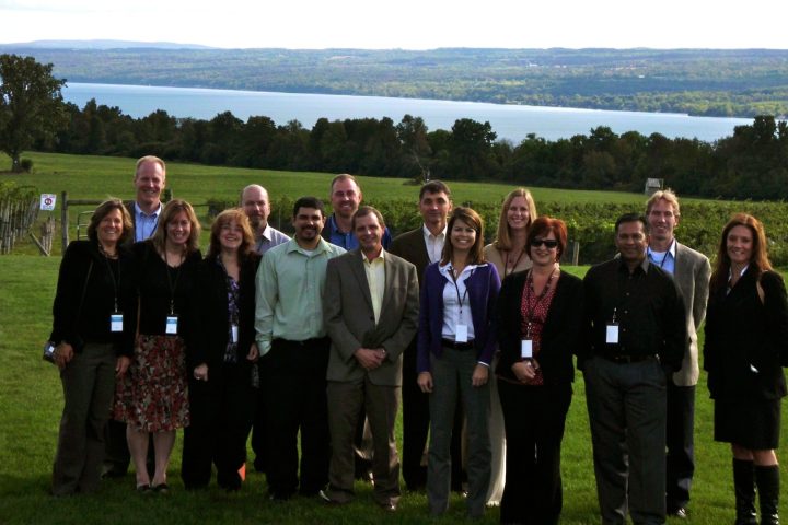 a group of people standing in a grass field posing for the camera