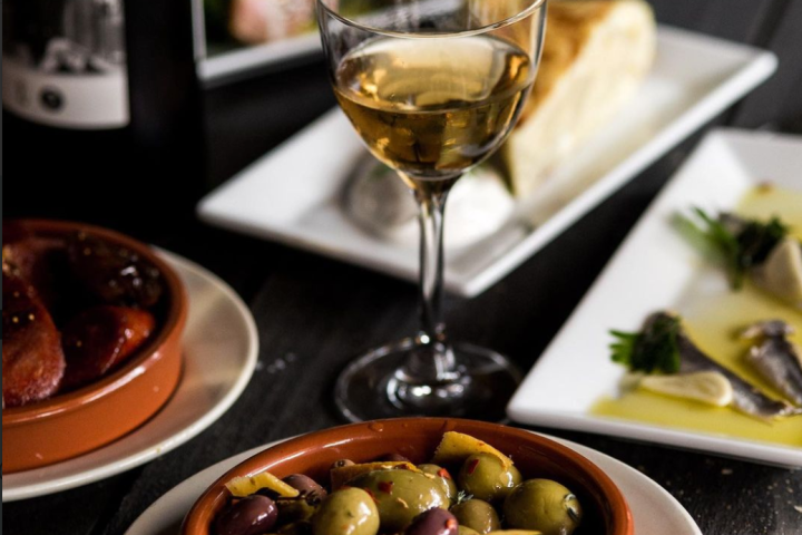 a close up of a plate of food and a glass of wine